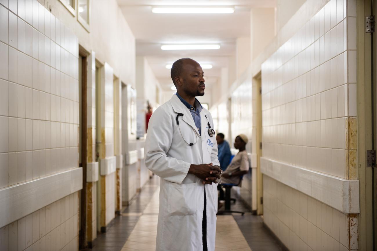 Illustrative image of a doctor standing in a hospital corridor.