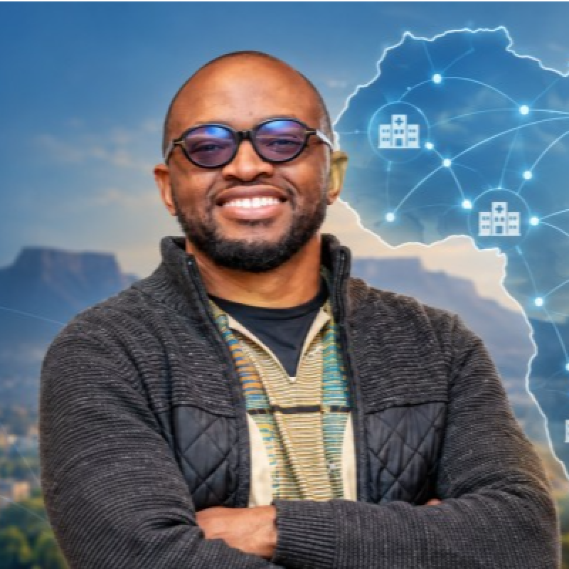 Dr Sam Musariri smiling, wearing glasses and a dark jacket.
